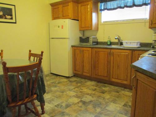 a kitchen with a white refrigerator and a table at Comerford's Ocean View Suites in Holyrood
