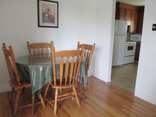 a dining room table with four chairs and a kitchen at Comerford's Ocean View Suites in Holyrood