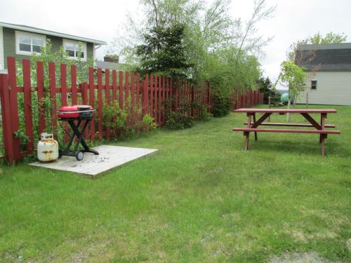 a picnic table in a yard next to a fence at Comerford's Ocean View Suites in Holyrood