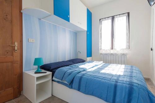 - une chambre bleue et blanche avec un lit et un escalier dans l'établissement Casetta di Ameglia, à Ameglia