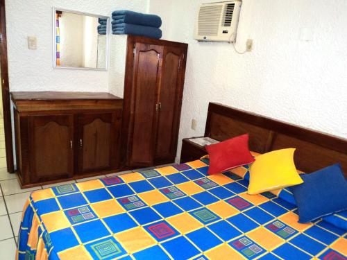 a bedroom with a bed with colorful pillows on it at Canadian Resort Veracruz in Costa Esmeralda