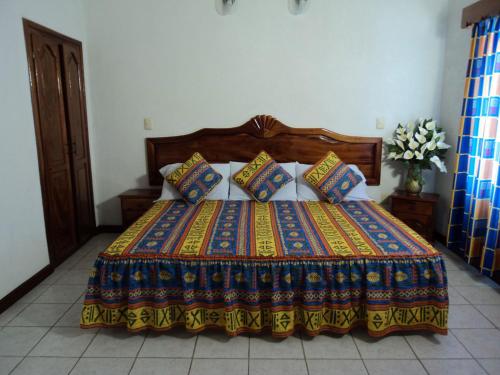 ein Bett mit einer bunten Decke und Kissen darauf in der Unterkunft Canadian Resort Veracruz in Costa Esmeralda