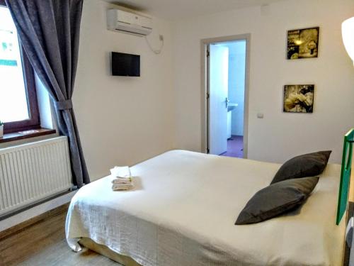 a bedroom with a white bed with pillows on it at Central Guesthouse in Bucharest