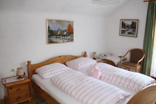 ein Schlafzimmer mit zwei Betten mit gestreiften Kissen darauf in der Unterkunft Pension Wolf in Steindorf am Ossiacher See