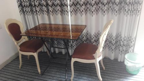 a wooden table with two chairs and a table and a table and chairs at Mango Roots in Gampaha