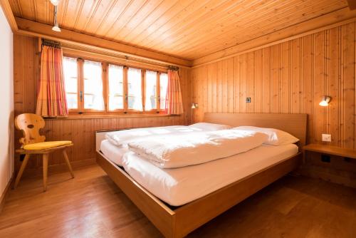 サースフェーにあるObere Gasse 11の木製の部屋に大型ベッドが備わるベッドルーム1室が備わります。