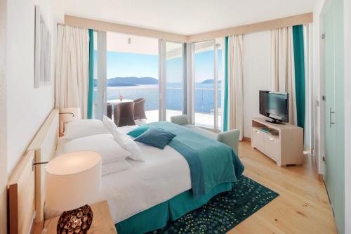 a bedroom with a large bed with a view of the ocean at Sun Gardens Dubrovnik in Dubrovnik