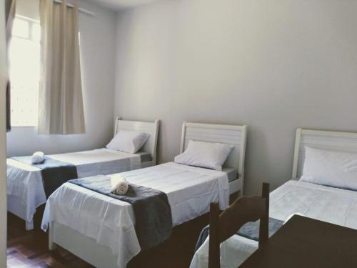 a room with two beds and a window at Hospedagem Solar do Rosário in Diamantina