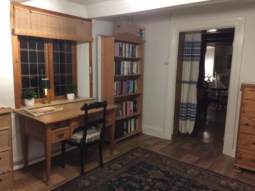 a home office with a desk and bookshelves at Björkåsa Gård Bed & Box in Annelöv