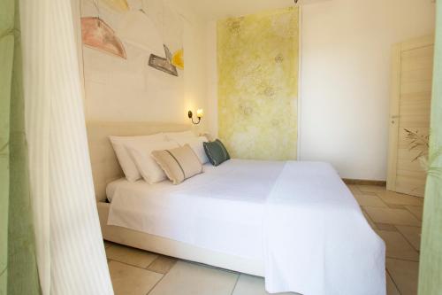 a bedroom with a large white bed in a room at Le Gioie - Villa Macchia Mediterranea - Splendida villa vista mare immersa nel verde in Torre Pali 
