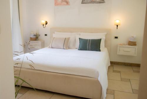 a bedroom with a large white bed with pillows at Le Gioie - Villa Macchia Mediterranea - Splendida villa vista mare immersa nel verde in Torre Pali 