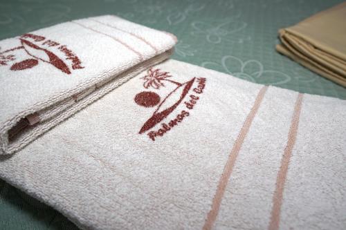 a white towel with flowers on it on a table at Palmas del Caribe in Punta Del Diablo