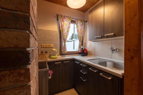 a small kitchen with a sink and a window at Chata HANA in Jeseník