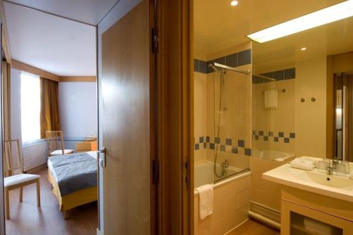 uma casa de banho com uma banheira, um lavatório e um chuveiro em Inter-Résidences Paris XV em Paris