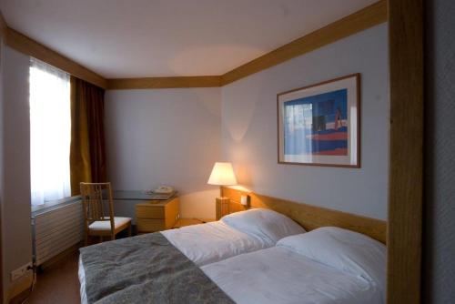 a hotel room with a bed and a window at Inter-Résidences Paris XV in Paris