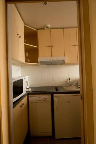 a small kitchen with white cabinets and a microwave at Inter-Résidences Paris XV in Paris