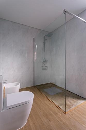 a bathroom with a glass shower and a toilet at Quinta do Passo in Ribeira Grande