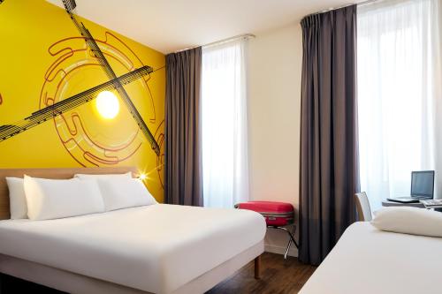 um quarto de hotel com duas camas e uma parede amarela em ibis Styles Marseille Gare Saint-Charles em Marselha