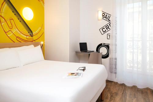 a bedroom with a white bed and a yellow wall at ibis Styles Marseille Gare Saint-Charles in Marseille