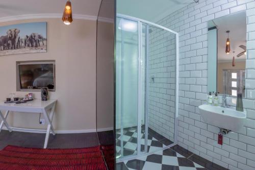 a bathroom with a glass shower and a sink at 90 On Wellington in Colchester