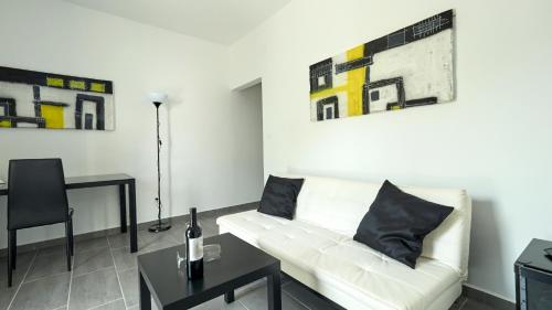 a living room with a white couch and paintings on the wall at B&B Villa Vela in Umag