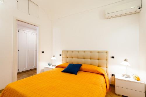 sypialnia z żółtym łóżkiem i 2 szafkami nocnymi w obiekcie Casa Dorothea 2 w mieście Positano