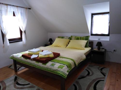 1 dormitorio con 1 cama con sábanas verdes y blancas en Kuća Za Odmor Jovanović, en Gornja Koprivna