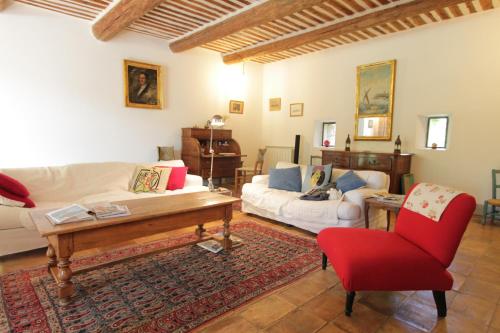 ein Wohnzimmer mit einem Sofa und einem Tisch in der Unterkunft Mas des Cigales in Pernes-les-Fontaines