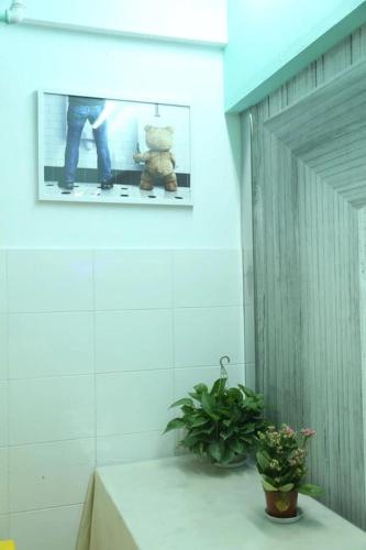 a teddy bear sitting on a counter in a room at Wuhan Worry-free Capsule Hotel in Wuhan