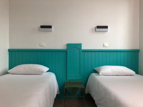 two beds sitting next to each other in a room at HALT HOTEL - Choisissez l'Hôtellerie Indépendante in Lattes