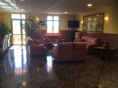 a living room with couches and tables and windows at Hotel Sonia Chipude in El Cercado