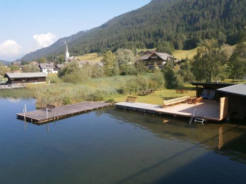 a dock in the middle of a body of water at Ferienwohnungen Knaller-Möd in Weissensee