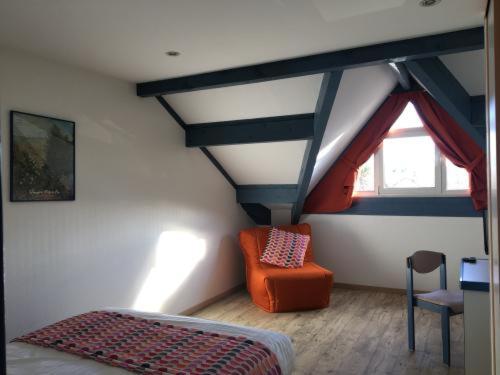 a room with a bed and a chair in a attic at Ecole Hôtelière Hôtel d'Application in Saint-Chély-dʼApcher
