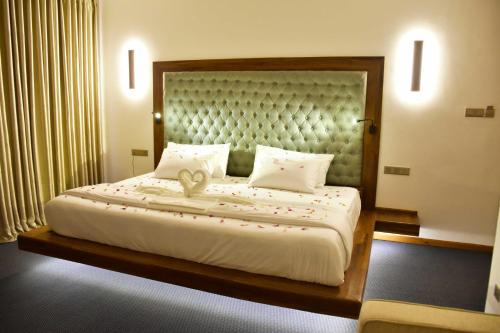 a bedroom with a large bed with a large headboard at Hilldale Retreat in Nuwara Eliya