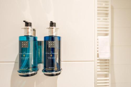 two bottles ofodorizers sitting on a shelf in a bathroom at LUDIEK eten en slapen in Havelte