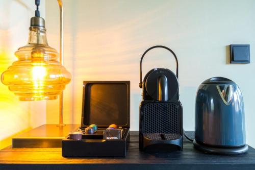 a table with a lamp a kettle and a tv at LUDIEK eten en slapen in Havelte