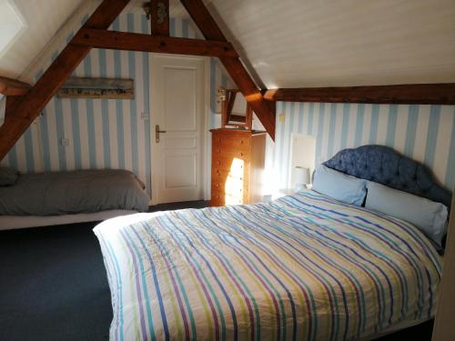 ein Schlafzimmer mit einem großen Bett im Dachgeschoss in der Unterkunft Le Moulin de Longueil in Longueil
