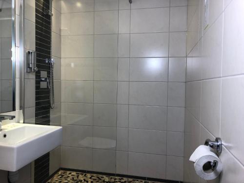 a white bathroom with a sink and a shower at HALT HOTEL - Choisissez l'Hôtellerie Indépendante in Lattes