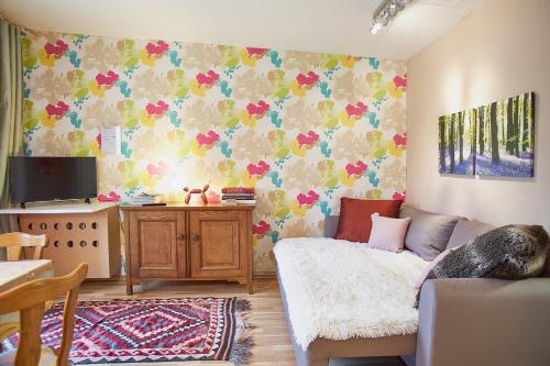 a living room with a couch and flowers on the wall at Ferienhaus Peggy in Kurort Oybin