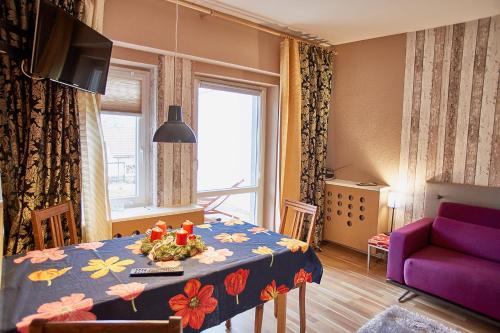 ein Wohnzimmer mit einem Tisch und einem lila Sofa in der Unterkunft Ferienhaus Peggy in Kurort Oybin