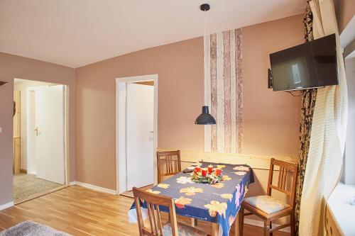a dining room with a table and chairs and a tv at Ferienhaus Peggy in Kurort Oybin