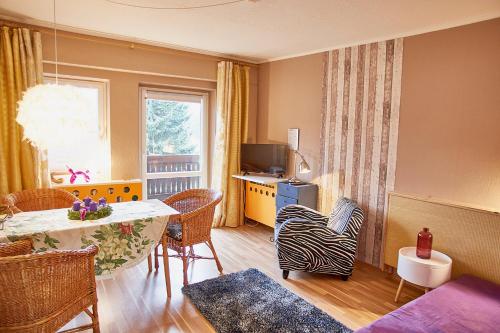 a living room with a table and chairs and a television at Ferienhaus Peggy in Kurort Oybin