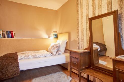 a small bedroom with a bed and a mirror at Ferienhaus Peggy in Kurort Oybin