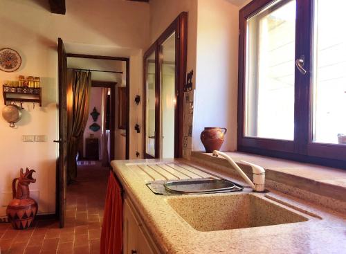 a kitchen with a sink and a window and a mirror at Haus Malerin mit Meerblick eingezäuntem Garten by ToscanaTour in Guardistallo