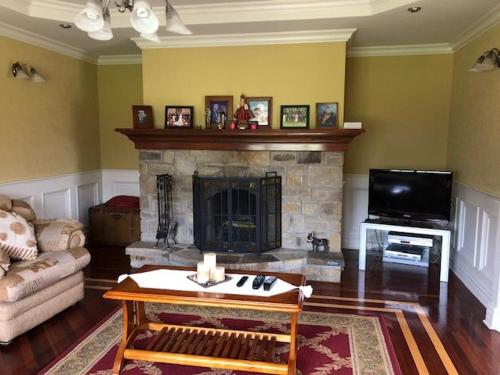 a living room with a couch and a fireplace at Beautiful Home on Lake Carrowmore in Belmullet