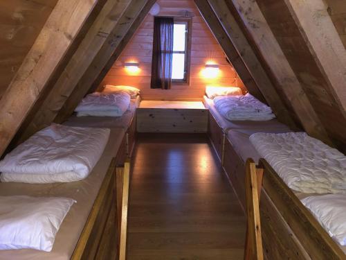 um quarto com 3 camas num sótão em Lofoten Feriesenter em Svolvær