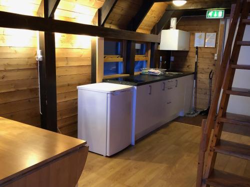 
a kitchen with a refrigerator, stove, sink and cabinets at Lofoten Feriesenter in Svolvær
