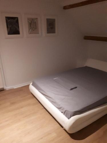 a bed in a room with a white mattress at markt 1 in Biervliet