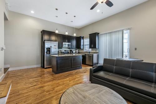 a living room with a couch and a kitchen at Stunning Condos - Heart of NOLA - Walk Everywhere in New Orleans