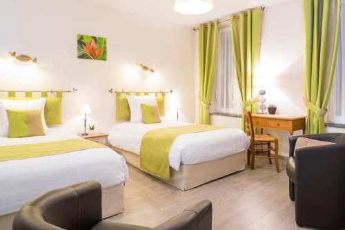 Remilly-AillicourtにあるLogis La Sapinièreのベッド2台とデスクが備わるホテルルームです。